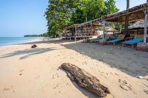 高兰Isara Lanta Beach Resort的沙滩上建有建筑,沙上有木头