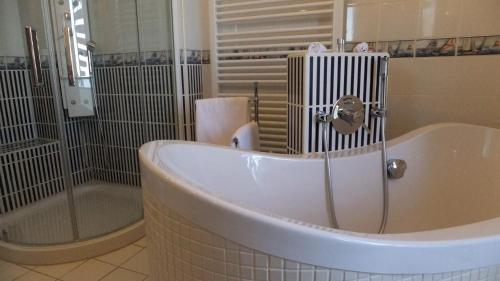 格赖夫斯瓦尔德乌特奇科餐厅酒店的带浴缸、淋浴和浴缸的浴室