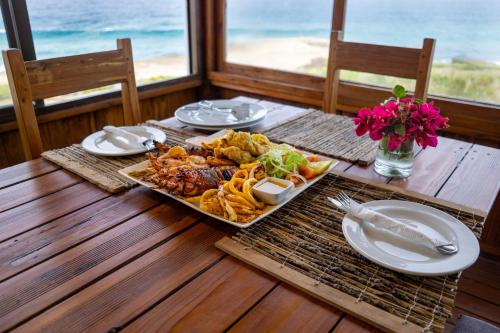 托弗海滩C-Mew Guest House的一张桌子,上面放着一张木桌上的盘子