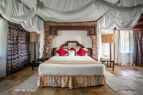 Archers Post萨罗瓦沙坝山林小屋 的一间卧室配有一张带红色枕头的大床