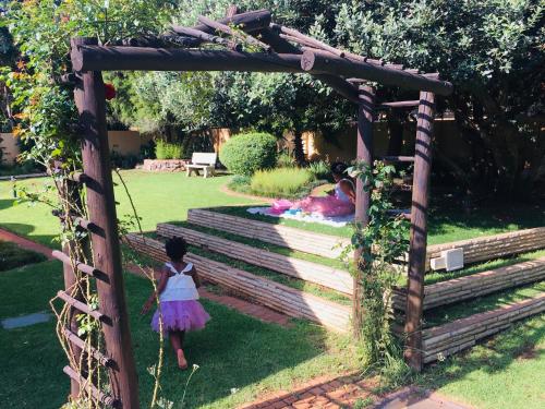 逊邱伦Riverton Manor的花园中一个小女孩在木拱下行走