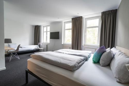 莱比锡BIG MAMA Leipzig的酒店客房配有两张床和一张书桌