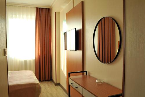 安卡拉Lion City Hotel Ankara的一间带镜子、一张床和一张桌子的卧室