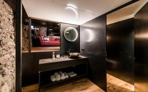 格洛伦萨Flurin Suites的黑色浴室设有水槽和镜子