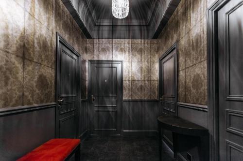 尼斯阿罗米酒店的一条带黑色门和红色长凳的走廊