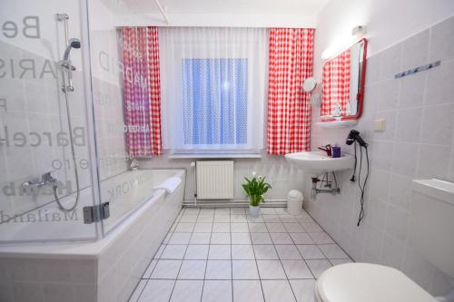 奥斯赛拜-塞林Hotel Forsthaus Sellin的带浴缸、卫生间和盥洗盆的浴室