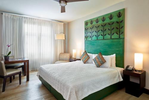 金斯敦R Hotel Kingston的卧室配有一张床,墙上挂着一幅绿色画作