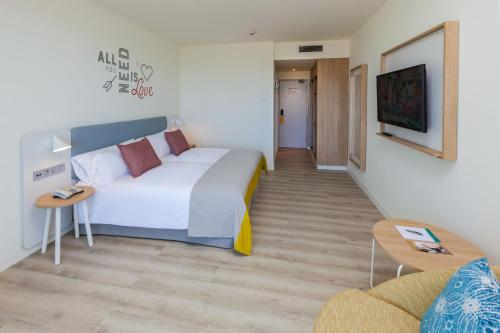 圣阿古斯丁Abora Interclub Atlantic by Lopesan Hotels的酒店客房设有一张大床和一张沙发。