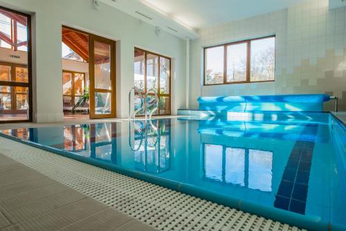 兹拉特霍里Hotel Praděd Thamm的一座蓝色水的大型游泳池