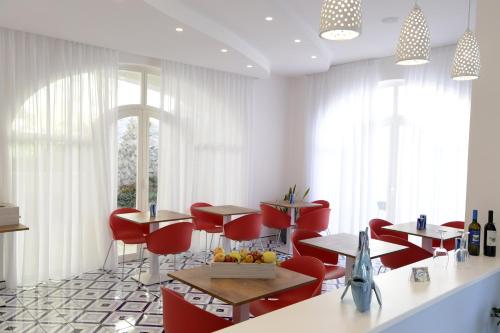 斯卡拉Palazzo San Giovanni Amalfi Coast的餐厅设有红色的椅子和桌子以及窗户。