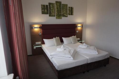 吕本瑙Hotel und Restaurant Zum Deutschen Hause的一间卧室配有带白色床单和枕头的床。