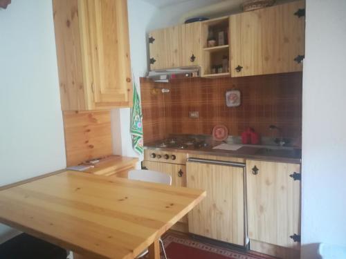 托尔诺monolocale Sabrina的厨房配有木制橱柜和木桌。