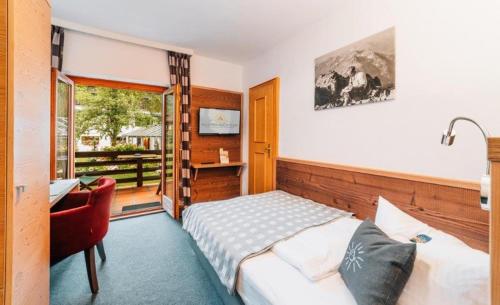 巴特维塞阿潘松尼酒店的一间卧室配有一张床、一张书桌和一个窗户。