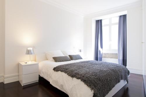 里斯本FLH Baixa Elegant Apartment的白色的卧室设有床和窗户