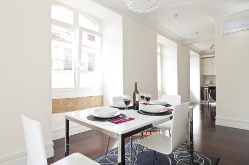 里斯本FLH Baixa Elegant Apartment的白色的用餐室配有白色的桌子和白色的椅子