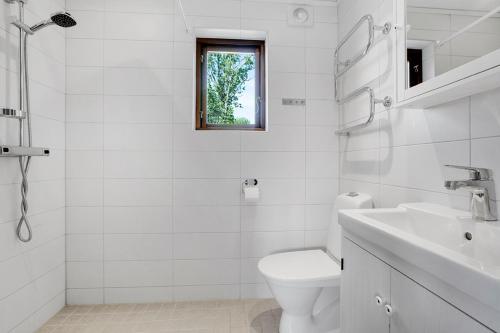 FidenäsFide Äventyrsby & Camping的白色的浴室设有卫生间和水槽。