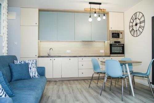 格但斯克Blueberry Apartment的客厅配有蓝色的沙发和桌子