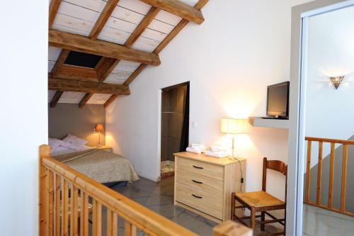 宗扎Appartement du Tourisme的一间卧室配有一张床、一台电视和楼梯