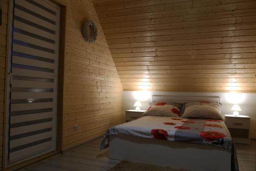 莱斯科Domki pod Polaną的一间卧室配有一张床,两台桌子上放着两盏灯