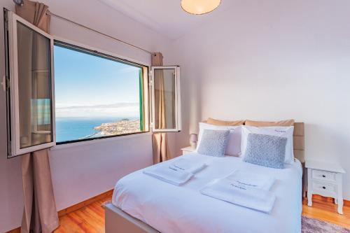 丰沙尔FLH Funchal Ocean View with Pool的一间卧室设有一张大床和大窗户
