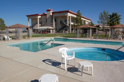 阿马戈萨山谷朗斯特里特赌场汽车旅馆的一座大楼前的游泳池,配有两把白色椅子