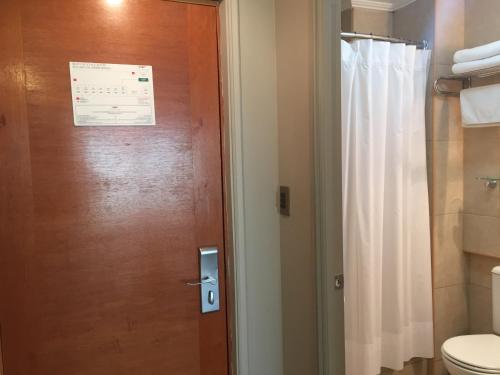 瓦尔帕莱索OHiggins Park Hotel的一间带卫生间的浴室和一扇门,门上标有标志