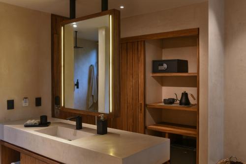 图卢姆Casa Agape Hotel Tulum with Beach Club Access的一间带水槽和镜子的浴室
