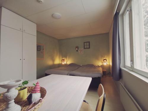 VirrankyläTaiga School的客房设有两张床、一张桌子和一张桌子以及椅子。