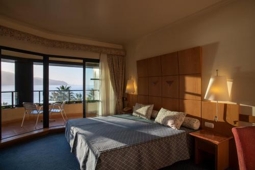 蓬塔德尔加达Monte Mar Palace Hotel的酒店客房设有一张床和一个阳台。