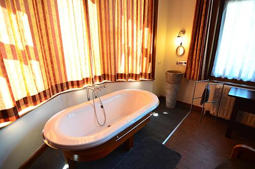 讷沙托La Citadine的带浴缸的浴室和窗户