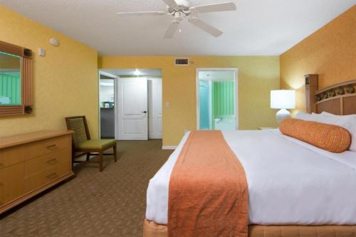 卡纳维拉尔角Cape Canaveral Beach Resort的酒店客房带一张大床和一把椅子