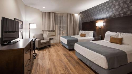 蒙特利尔Best Western Plus Montreal East的酒店客房设有两张床和一台平面电视。