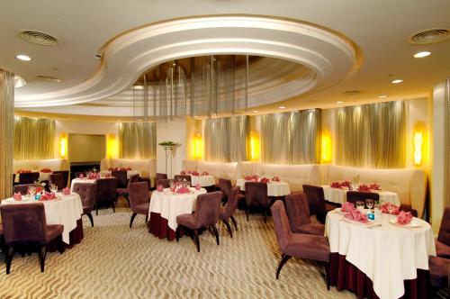 澳门澳門君怡酒店的一间带桌椅和天花板的用餐室