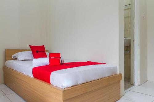 打横RedDoorz near Universitas Siliwangi Tasikmalaya的一间卧室配有一张带红色枕头的床