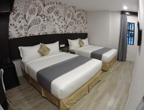 八打灵再也Hotel MM @ Sunway的一间卧室设有两张床和一堵墙