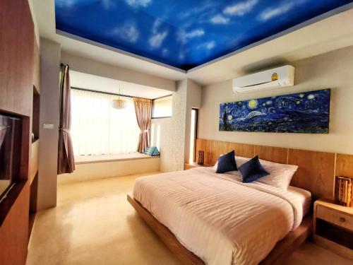 清迈Hideaway的一间卧室配有一张蓝色天花板的床