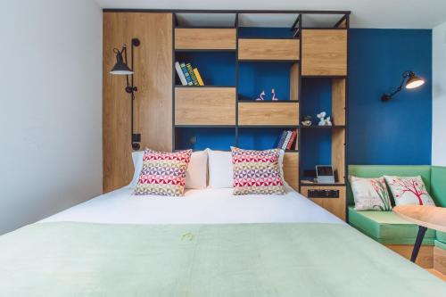 上海康铂酒店（上海淮海路店）的一间卧室设有一张大床和蓝色的墙壁
