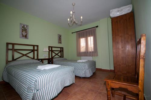 比利亚尔瓦德拉谢拉阿罗鲁拉尔拉富恩特酒店的配有两张床的客房,设有绿色的墙壁和窗户