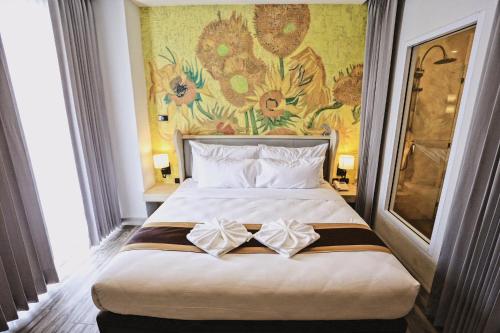 坤敬光明酒店的卧室配有一张大床,墙上挂有绘画作品