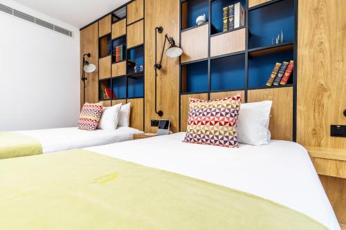 上海康铂酒店（上海淮海路店）的配有木墙和架子的客房内的两张床