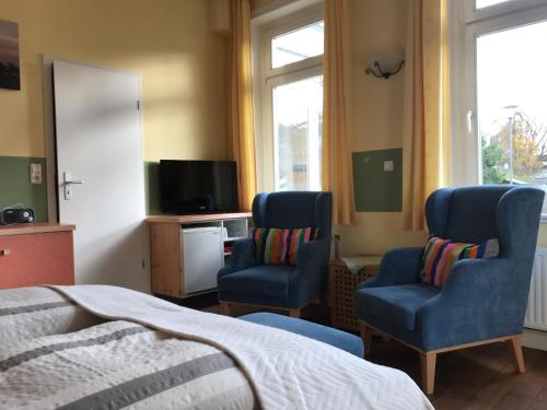 蒂门多弗施特兰德维拉莫温斯坦恩度假村的一间卧室配有两把椅子、一张床和电视