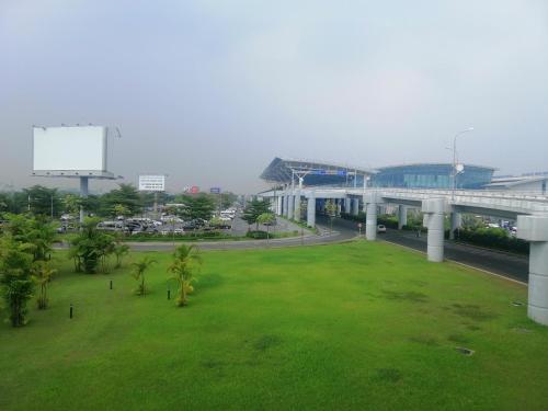 河内Roma Hotel Noi Bai airport的一座带桥梁和公路的绿色公园
