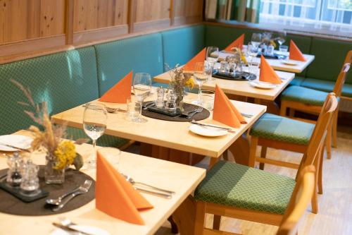 萨尔茨堡海夫特豪夫酒店的餐厅的一排桌子,有橙色餐巾