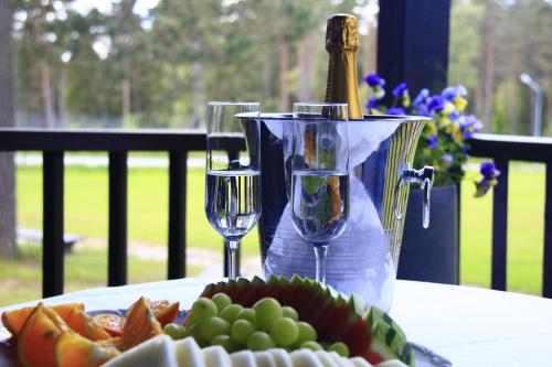 穆尔舍Mullsjö Hotell & Konferens的一张桌子,上面放着两杯葡萄酒和一盘水果