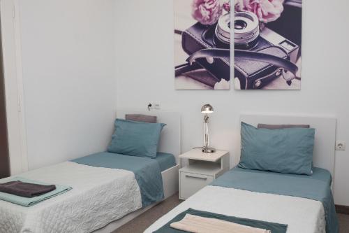 雅典Dimitras Apartment的一间卧室配有两张带蓝白色床单的床