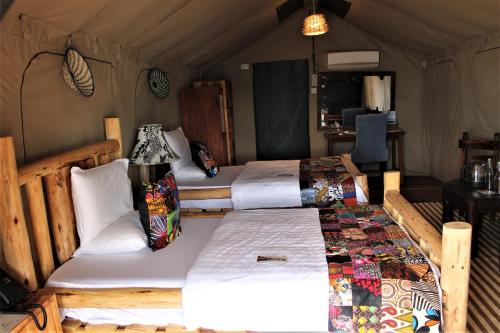 姆万扎Wag Hill Lodge & Spa的一间帐篷内带两张床的卧室