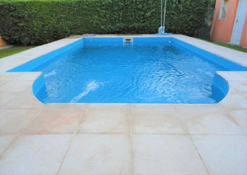 维斯塔尔巴Jazmin de Lluvia的游泳池铺有瓷砖地板,拥有蓝色的海水