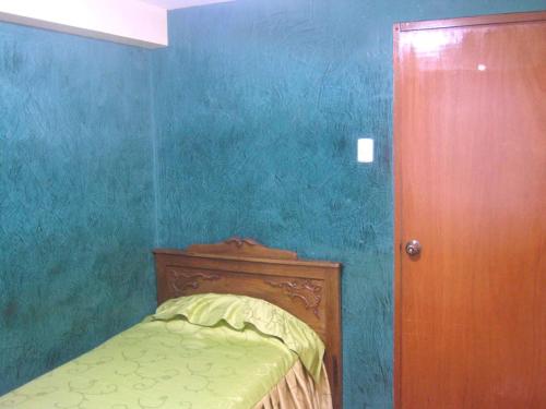 库斯科Hospedaje Pumacurco Betty的一间蓝色的卧室,配有一张床和一个木门
