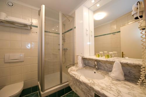 圣卡尼兹桑尼Spa酒店的一间带水槽、淋浴和卫生间的浴室