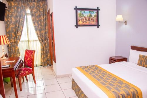 杜阿拉德加勒王子酒店的一间卧室配有一张床、一张桌子和一把椅子
